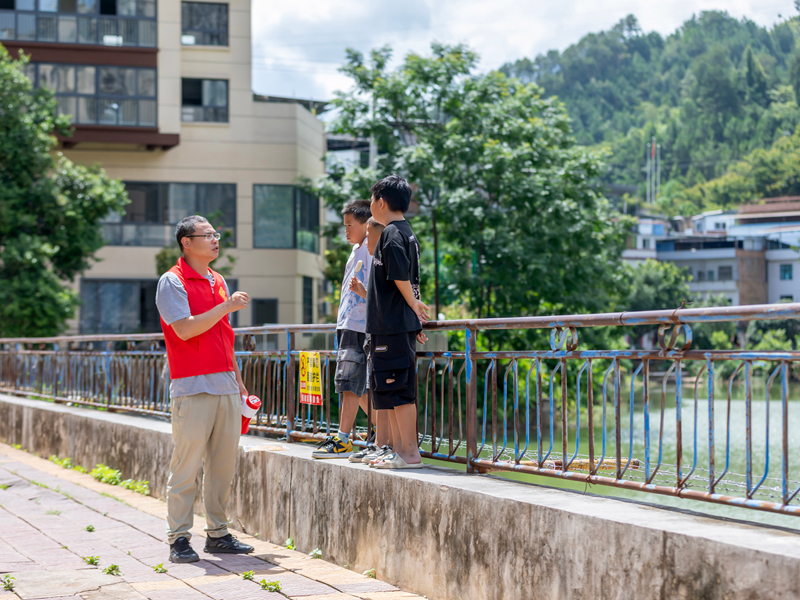 贵州省黔南布依族苗族自治州罗甸县斛兴街道办的工作人员在大乐亭给小朋友普及防溺水相关知识。