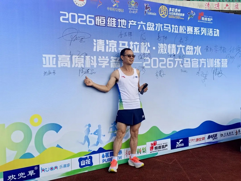 跑者在主题签到板前签名留念、打卡拍照。