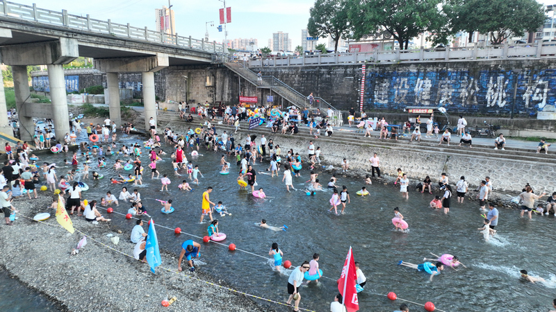 家长陪同孩子在亲水区嬉水。
