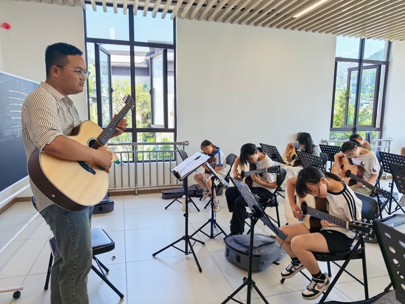 1、老师教学生们弹吉他。