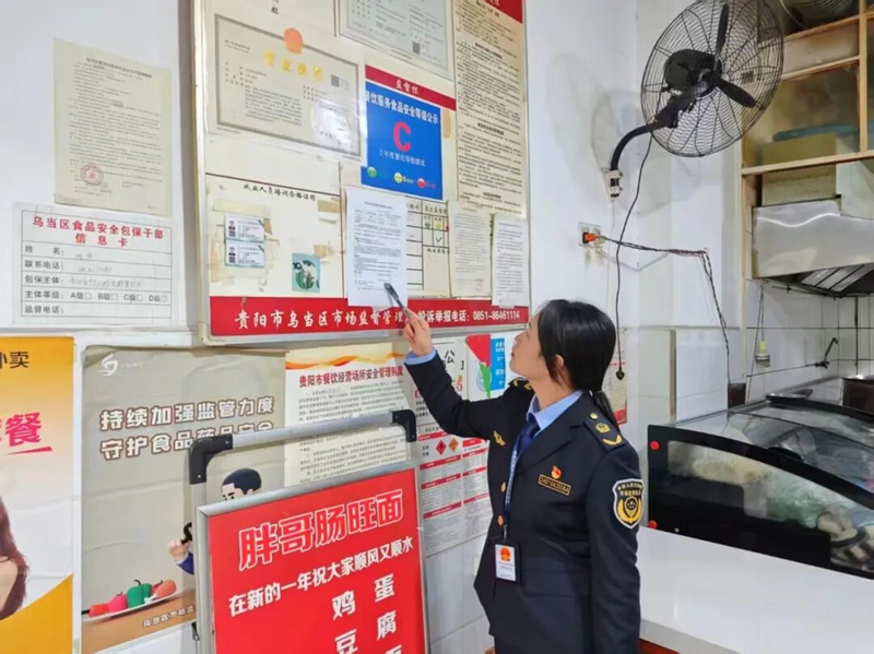 党员攻坚小组成员对餐饮店进行检查。区市场监管局供图