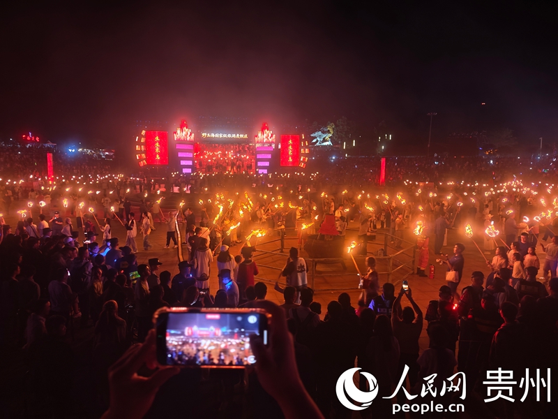 游客围拢篝火跳达体舞。人民网 黄小桃摄