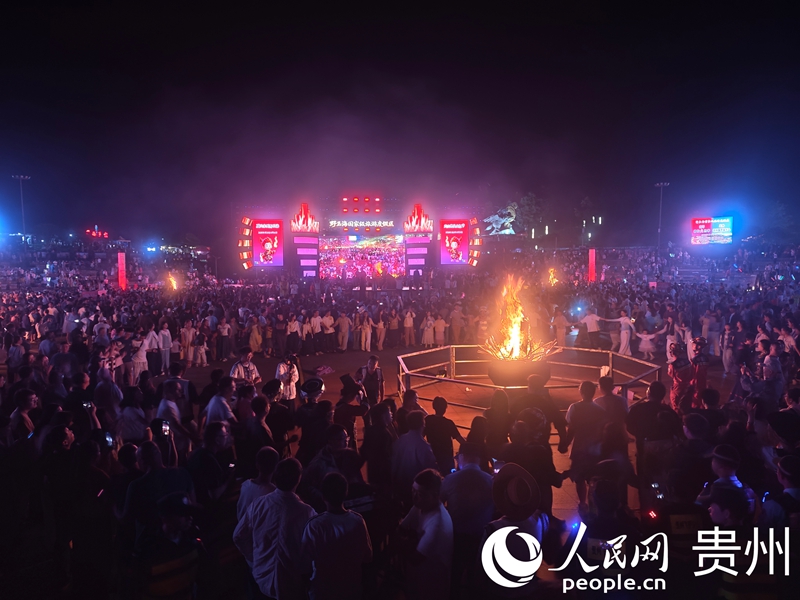 游客围拢篝火跳达体舞。人民网 黄小桃摄