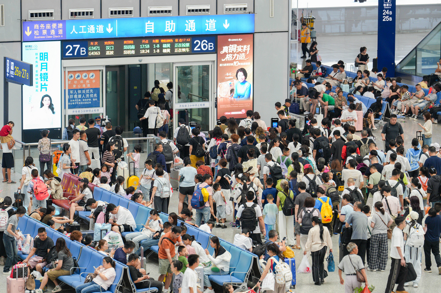 2026年7月19日，贵州贵阳北站迎来暑运客流高峰，车站候车厅内的旅客正依次检票登车。 