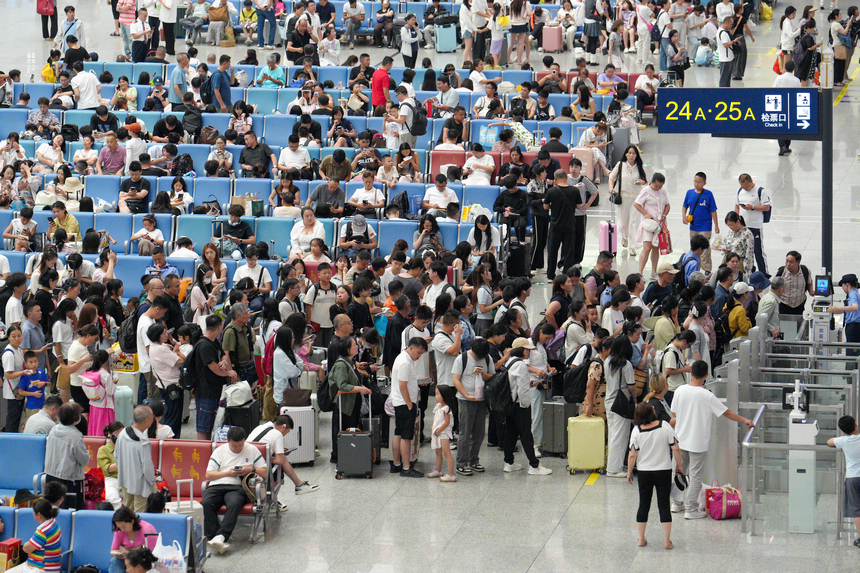 2026年7月19日，贵州贵阳北站迎来暑运客流高峰，车站候车厅内的旅客正依次检票登车。 