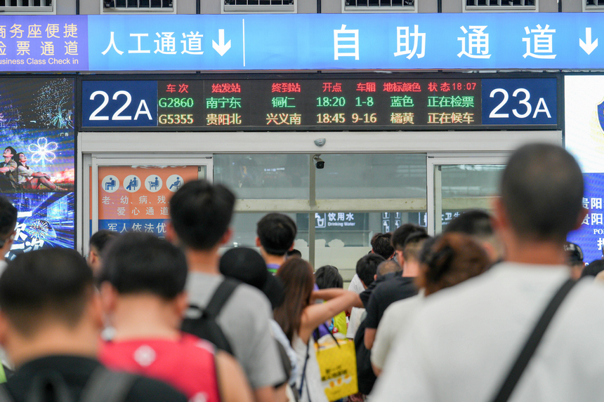 2026年7月19日，贵州贵阳北站迎来暑运客流高峰，车站候车厅内的旅客正依次检票登车。 