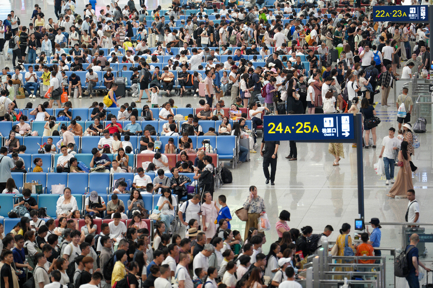 2026年7月19日，贵州贵阳北站迎来暑运客流高峰，车站候车厅内的旅客正依次检票登车。 