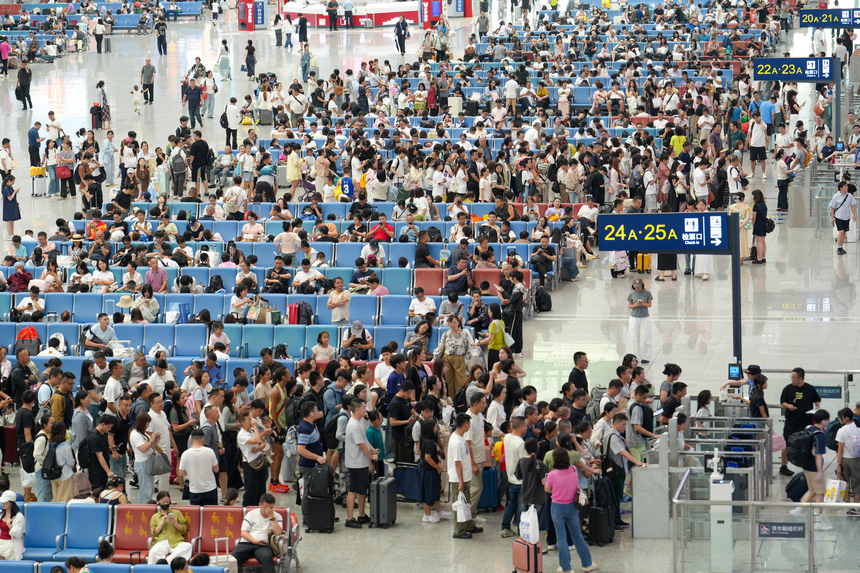 2026年7月19日，贵州贵阳北站迎来暑运客流高峰，车站候车厅内的旅客正依次检票登车。 