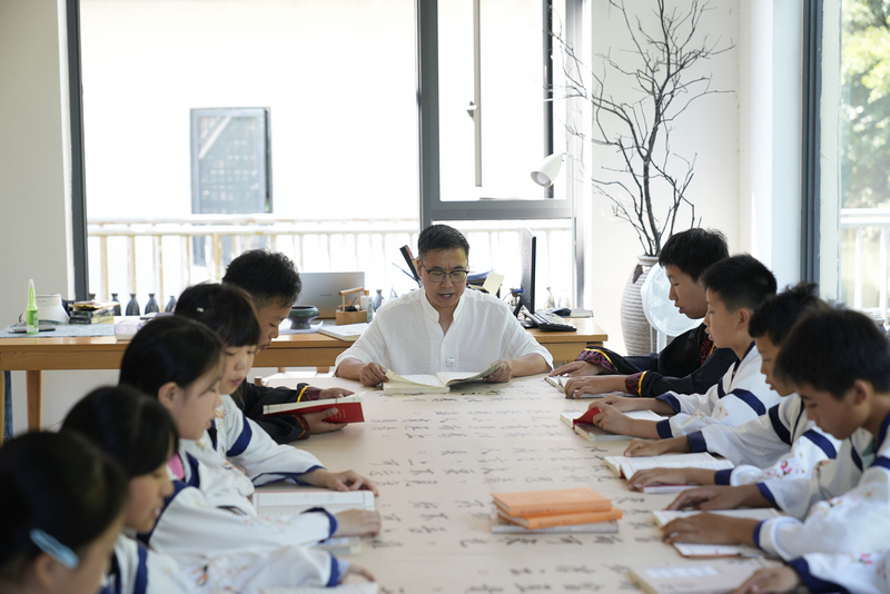 言语堂创始人梁洪铭正在带领学生诵读《论语》。