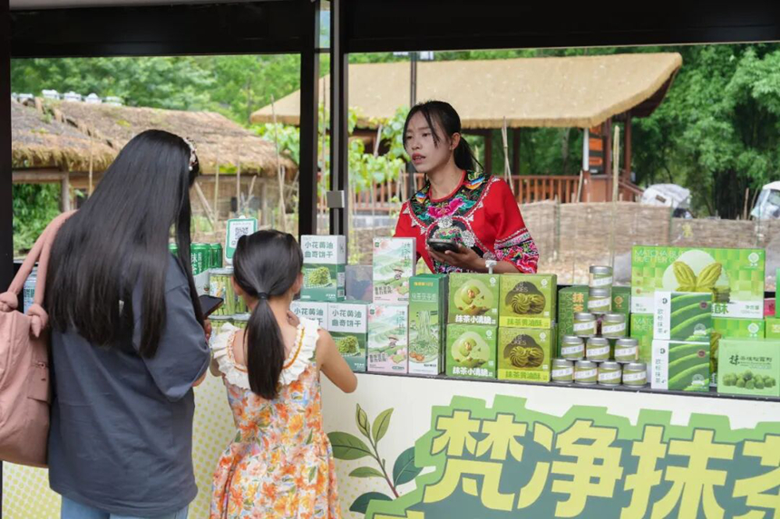 游客在铜仁市江口县太平镇云舍景区一家商铺选购抹茶产品。申逸恺 摄