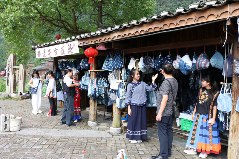 游客驻足挑选当地传统工艺品。