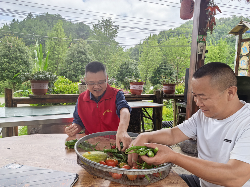 王国伦到“翠河青椒鱼”处走访帮厨。