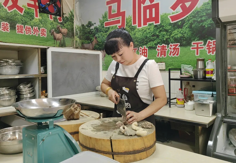 4、马临罗自有羊肉店店主罗小琴在切羊肉。罗利飞 摄