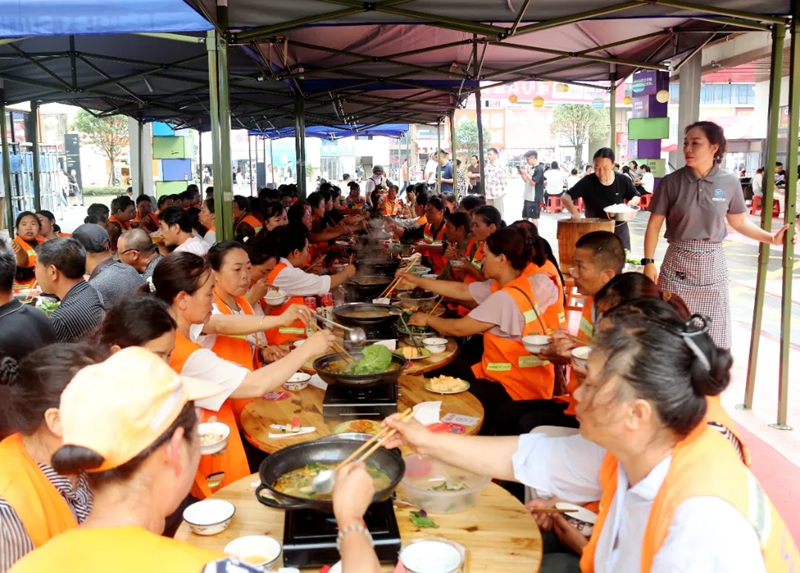 橙衣环卫工围坐吃热辣火锅,烟火里满是温情。罗利飞 摄.jpg