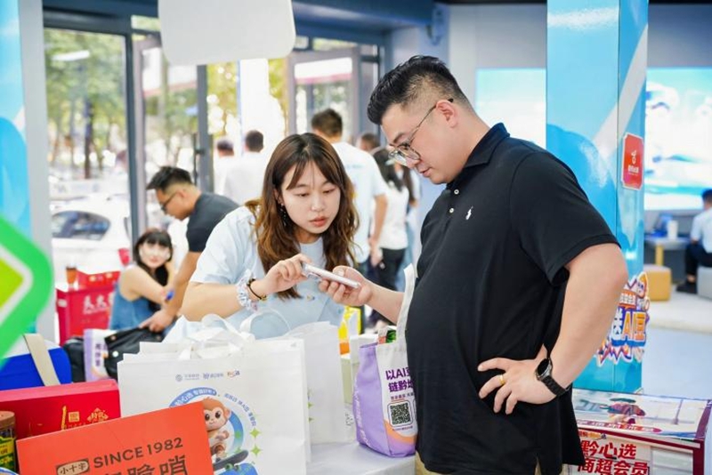 4 图为营业厅内工作人员向市民演示 “黔心选” 小程序 AI 豆亮码付操作.jpg
