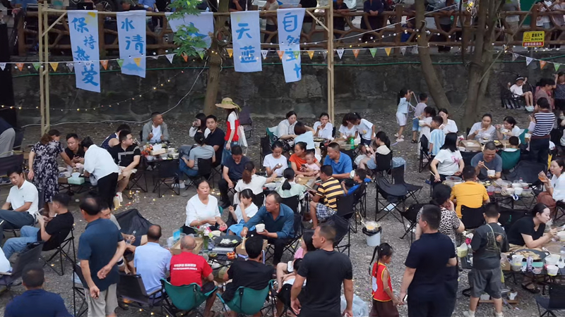 市民游客在河畔烧烤，烟火味十足。