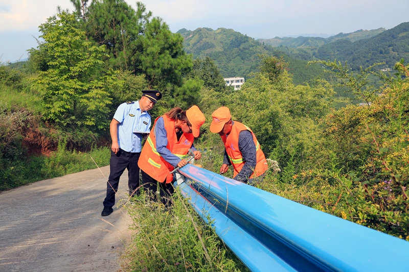 工作人员对道路波形护栏进行巡检养护。（彭凯 摄）.JPG