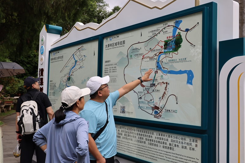 2、游客細看導覽圖，規劃景區游玩路徑。黃果樹旅游區供圖.JPG