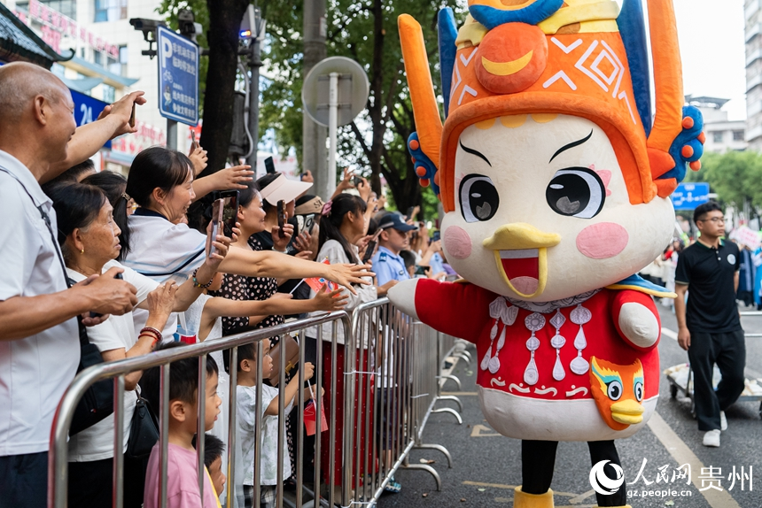 民族团结大巡游活动现场，参加巡游的吉祥物与观看巡游的市民互动。人民网记者 涂敏摄