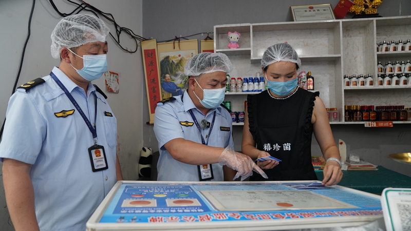 图为2026年8月4日务川自治县市场监督管理局工作人员正在检查食品安全.JPG，