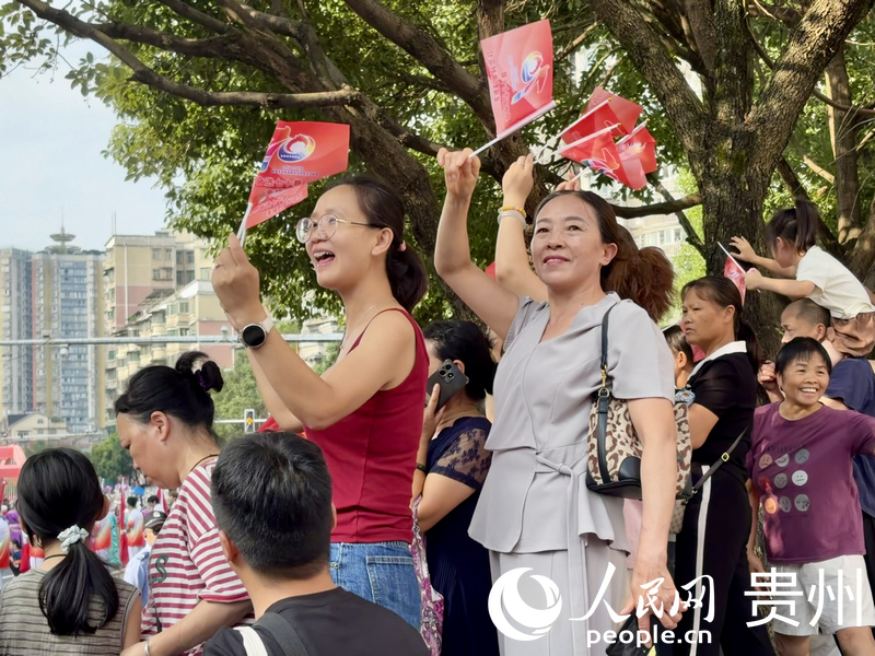 群众沿街围观，摇旗庆祝。人民网记者 李丽萍摄