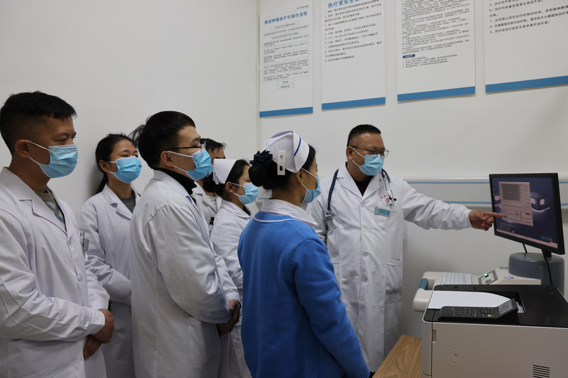 东西部协作帮扶专家詹增钦医生在教授如何使用热疗机。