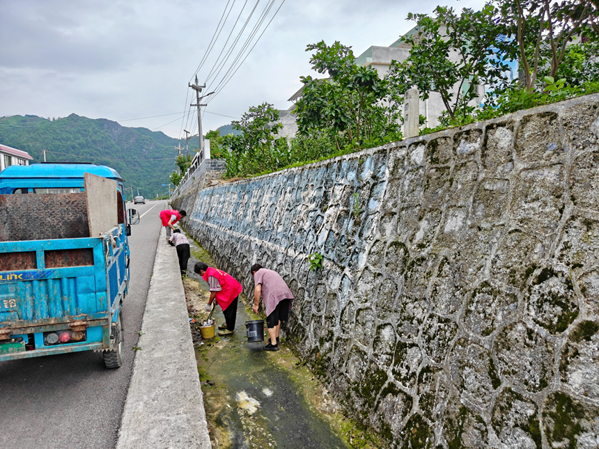 志愿者和村民清扫环境卫生。