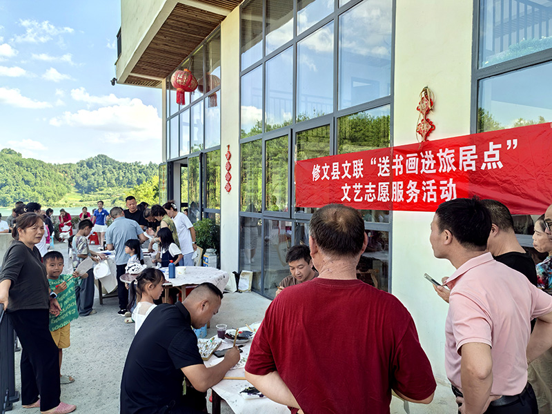 修文县文联组织本土文艺家、书画爱好者到场，挥毫泼墨为旅居客人绘制彩扇。
