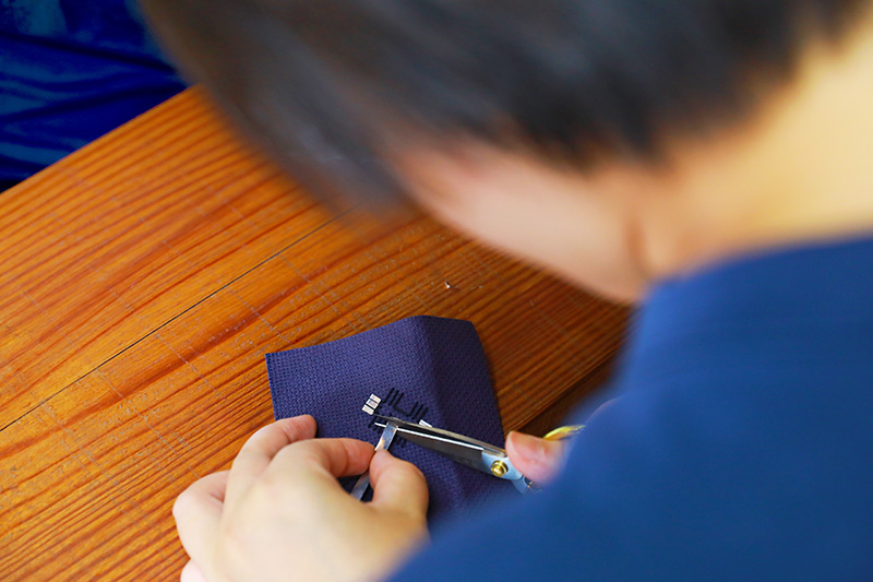 游客正在為繡片上錫條。