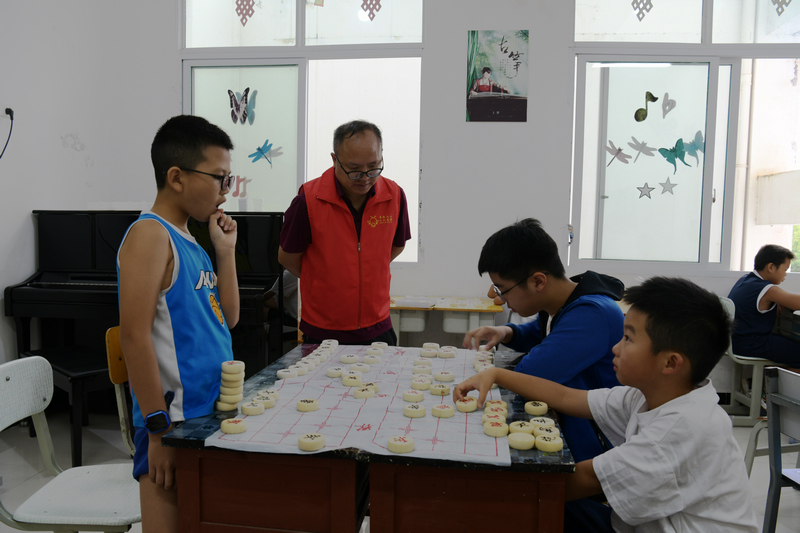志愿者免费教孩子们下象棋。