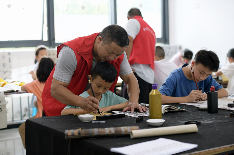 志愿者免费教孩子们练习书法。