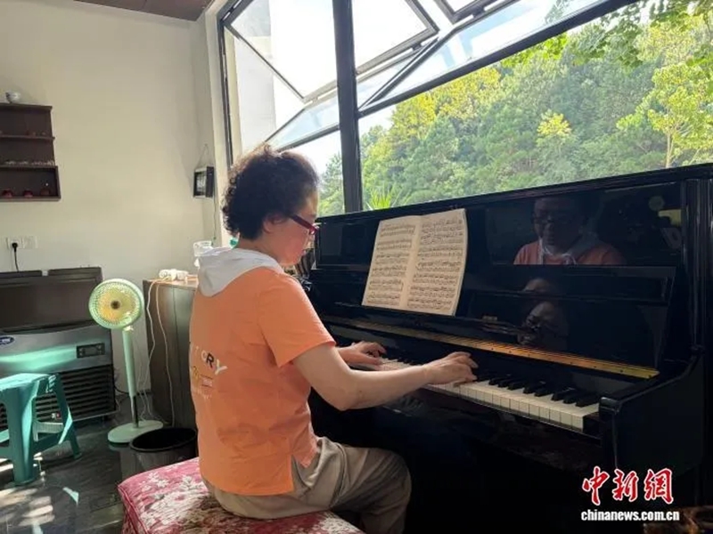 旅居在贵阳市乌当区羊昌村的游客在弹钢琴。