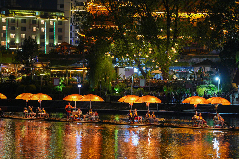 游客乘坐龙舟竹筏泛游锦江，尽览两岸城市夜景。