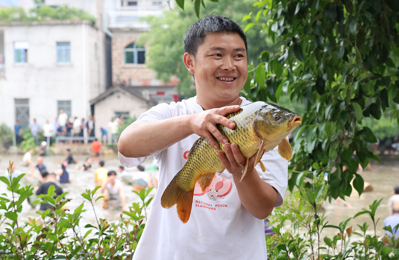 圖為村民在展示自己捉到的魚。楊健攝