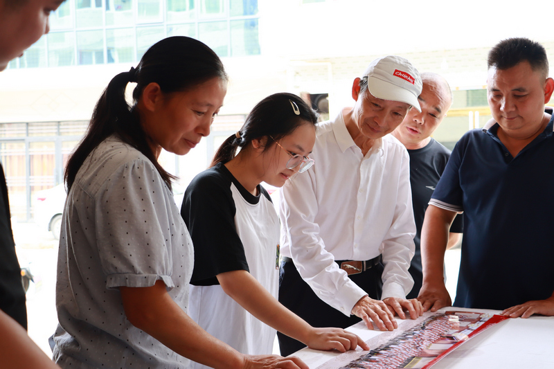 黄金龙正和家人、学生、家长一起分享合影当天的情形。王林爱摄
