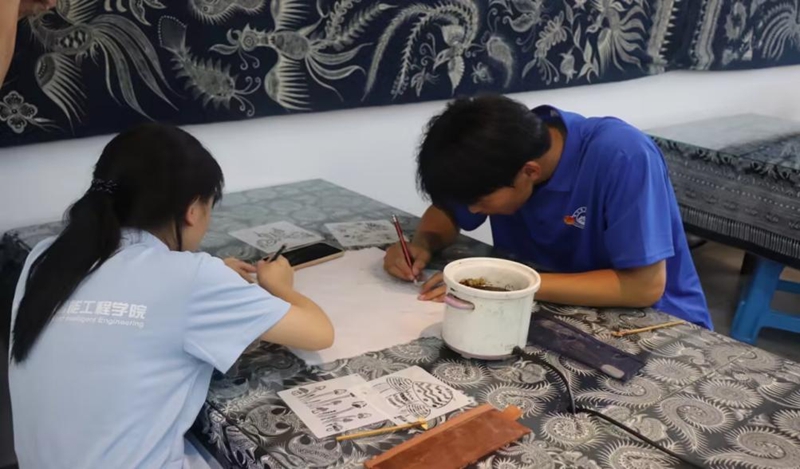 实践团在非遗传承人王方周指导下体验蜡染制作。