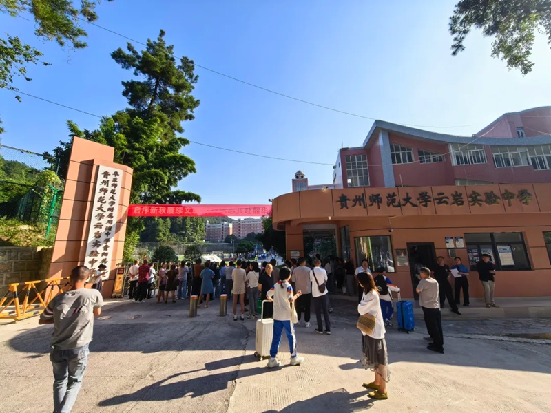 校门外，送学家长们驻足观看。