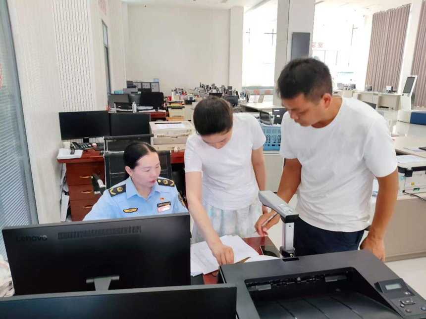 施秉县市场监督管理局工作人员在为预约办事企业办理相关执照。