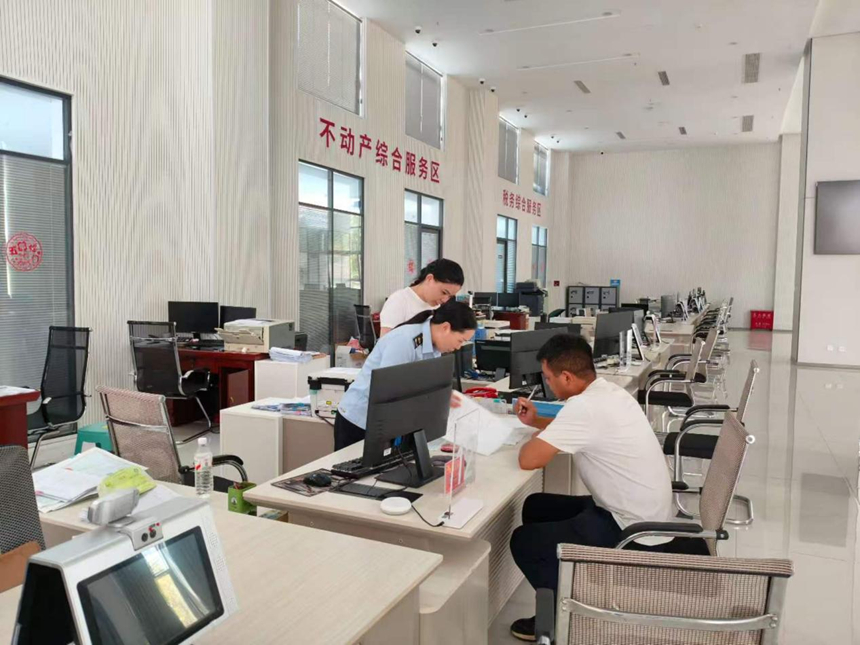 施秉县市场监督管理局工作人员在为预约办事企业办理相关执照。
