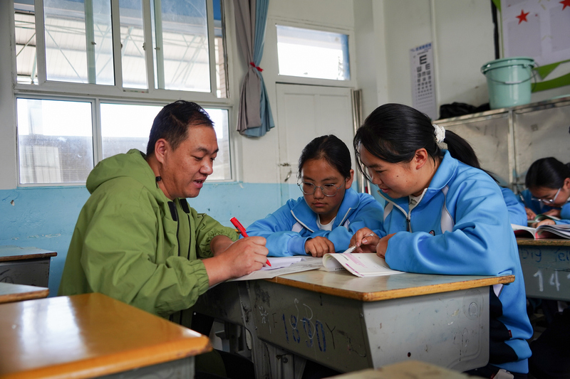 9月5日，在威宁自治县思源实验学校，值班老师在对周末留校学生进行学业辅导。赵庆能摄