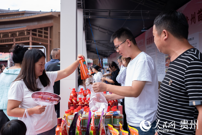 第三届凯里酸汤产业发展大会现场，参观者在会场外的展位上挑选酸汤产品。人民网记者 涂敏摄