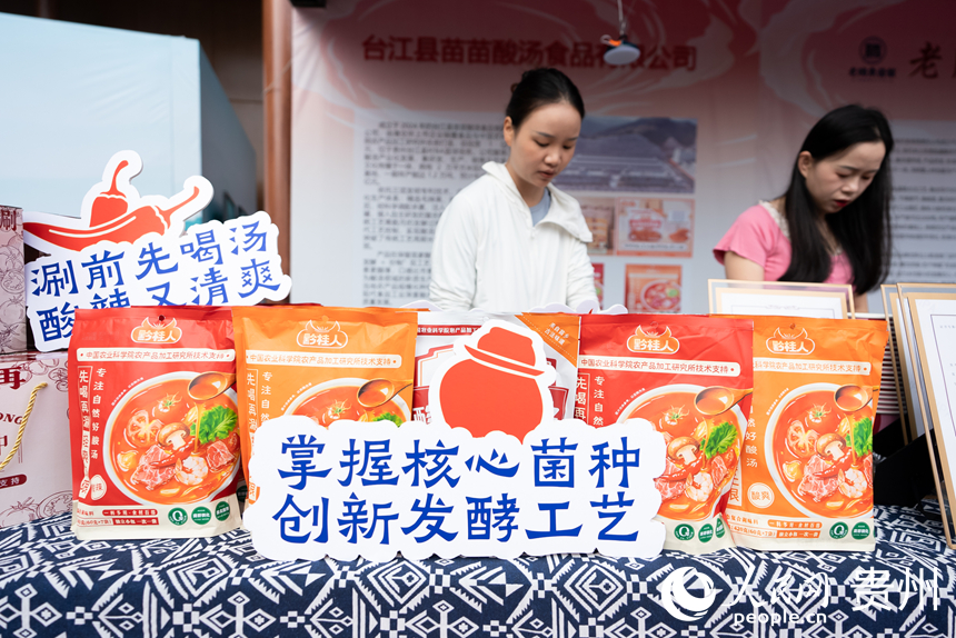 第三届凯里酸汤产业发展大会现场，工作人员在整理展出的酸汤产品。人民网记者 涂敏摄