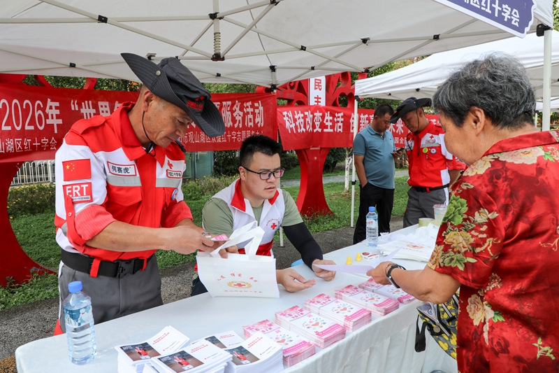 2、紅十字志願者向居民發放宣傳資料，科普應急救護知識。.jpg
