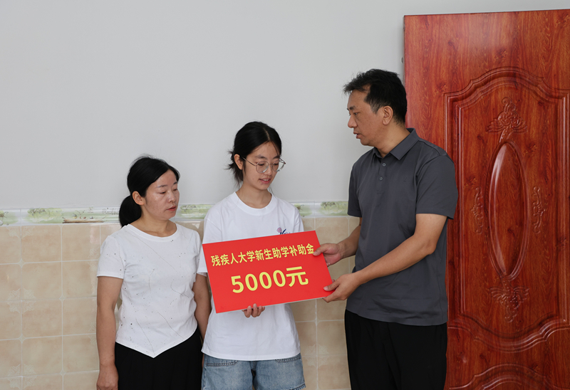 圖為印江自治縣殘聯工作人員在木黃鎮木良村大學新生冉玲可家中走訪。梅亞軍攝
