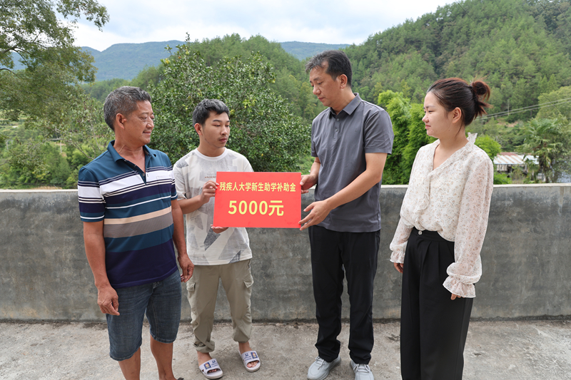 圖為印江自治縣殘聯工作人員在合水鎮白元村的一名肢體殘疾大學新生家長走訪。梅亞軍攝