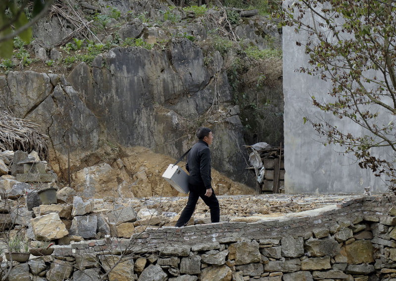 蔣才明背起藥箱行走在大山中為村民看病。周海東攝
