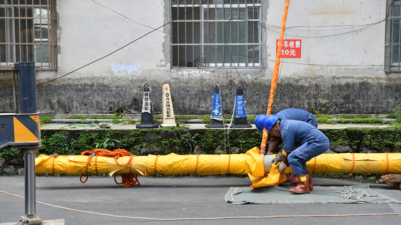 工作人员为电杆包裹绝缘毯。
