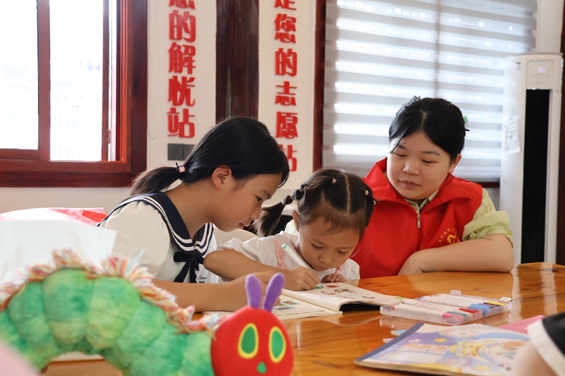 反乡大学生志愿者辅导儿童作业。