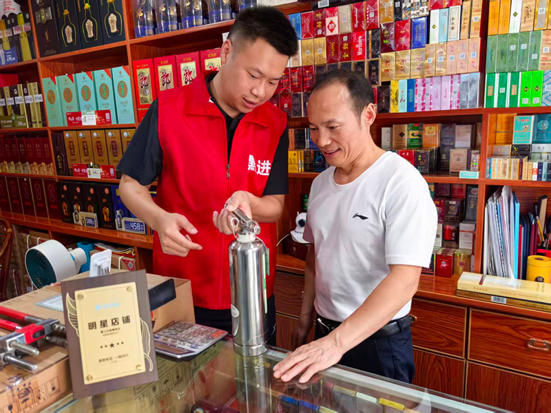 圖為：消防安全志願服務隊向零售戶介紹消防器材使用方法。