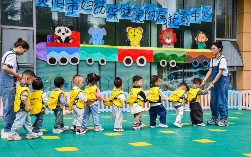 貴陽市婦幼保健院附屬托育中心保育老師帶領孩子們開展益智游戲。